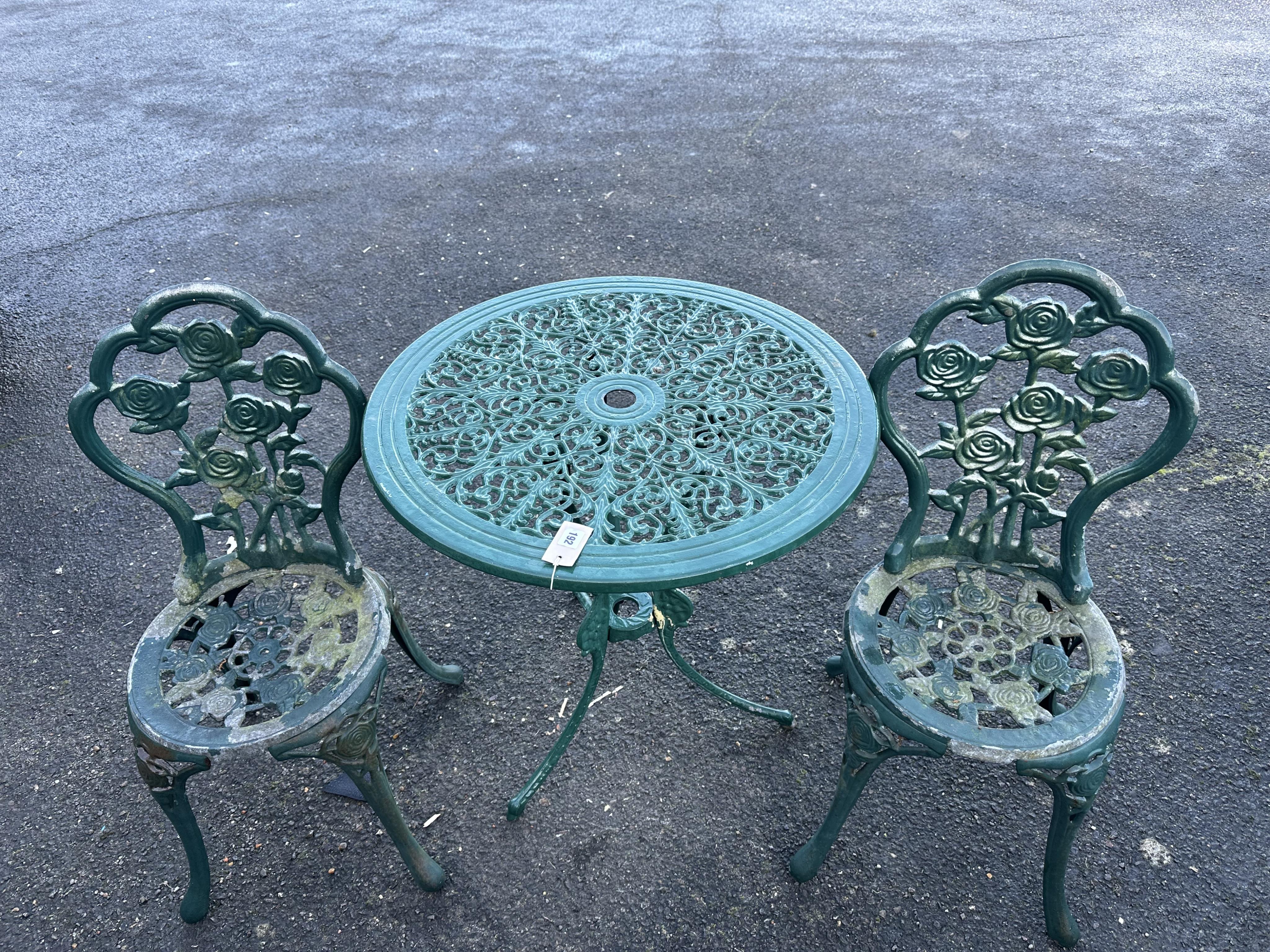 An aluminium garden table, diameter 68cm and a pair of chairs. Condition - poor